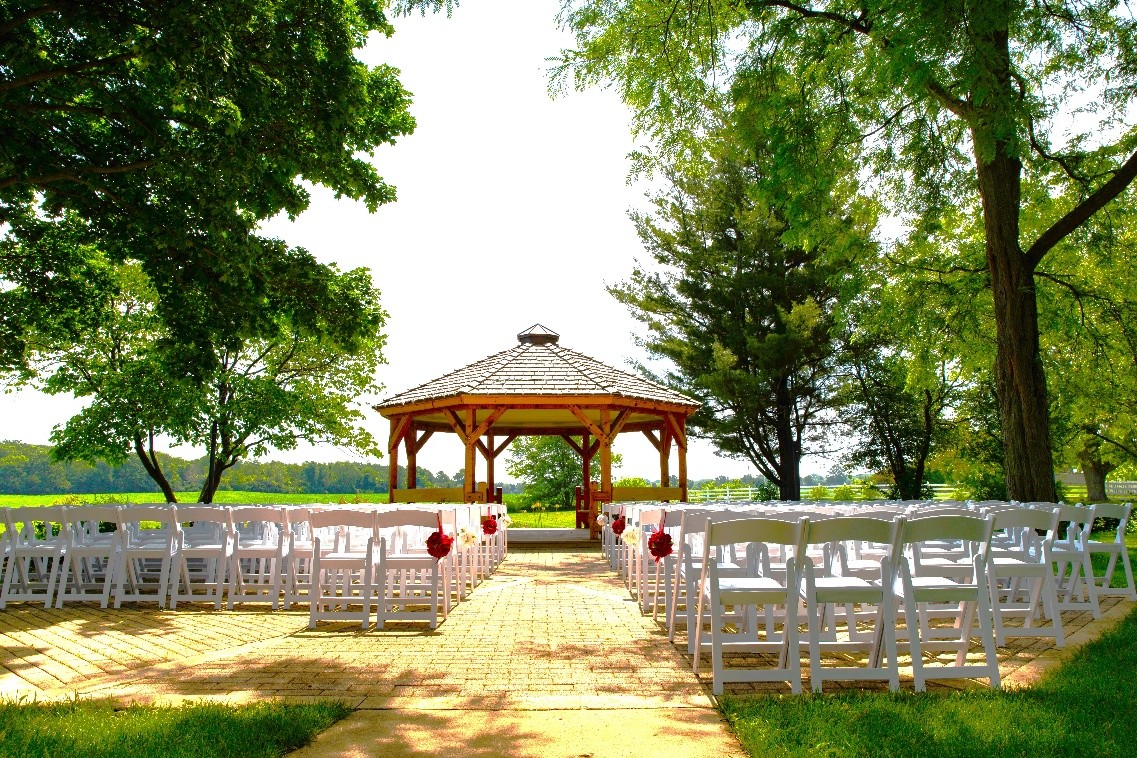 Gazebo ceremony site with white chairs